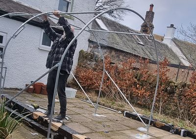 Alex putting up the polytunnel on the patio - 2022